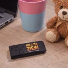 Czarny pendrive Nie z Tej Ziemi na biurku obok laptopa, kubka i pluszowego misia