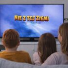 Mama z dwójką dzieci ogląda serial Nie z Tej Ziemi na telewizorze, pendrive wpięty do gniazda USB
